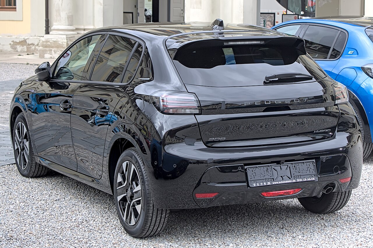 Rear three-quarter view of a black Peugeot 208 Hybrid at an outdoor display